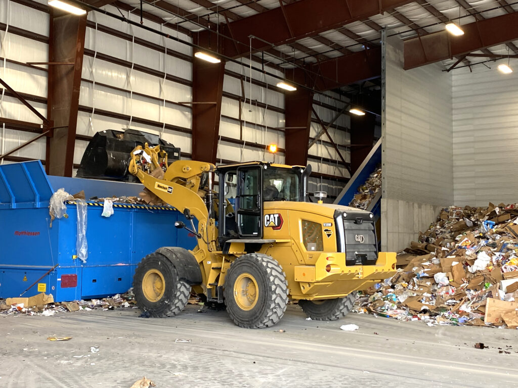 yellow CAT recycling truck in action